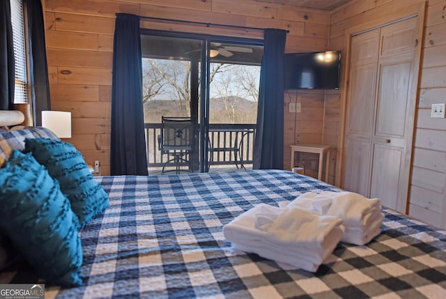 bedroom with access to exterior, wooden walls, and a closet