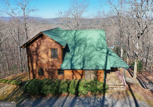 view of side of property with metal roof and faux log siding