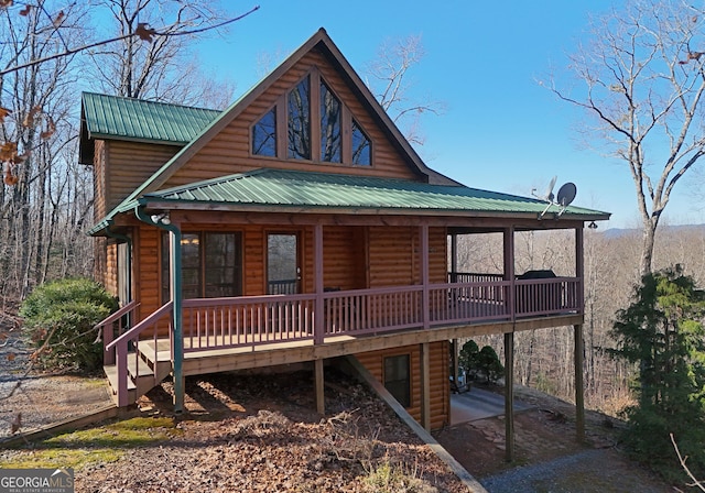 view of front of property featuring faux log siding and metal roof