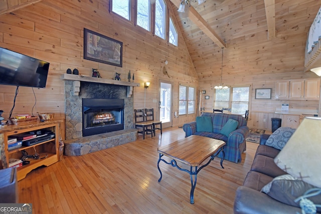 living room featuring wooden walls, a fireplace, and a wealth of natural light