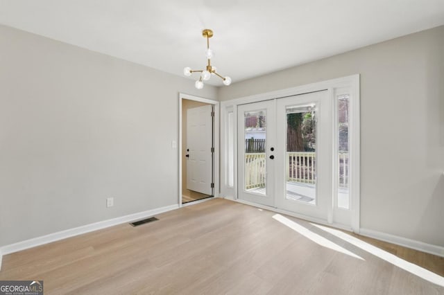 interior space with a notable chandelier, visible vents, french doors, and baseboards