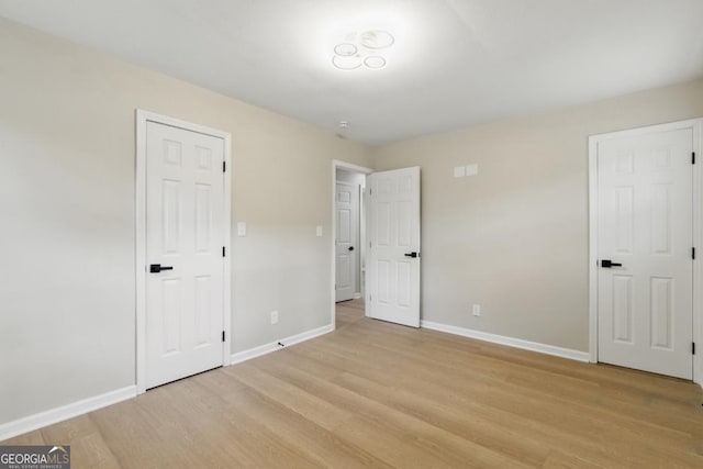 unfurnished bedroom with baseboards and light wood-style floors