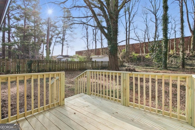 wooden terrace with a fenced backyard