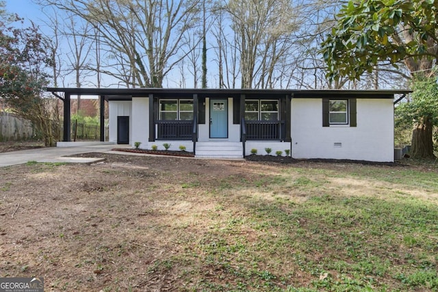 ranch-style home with an attached carport, a front yard, covered porch, crawl space, and driveway