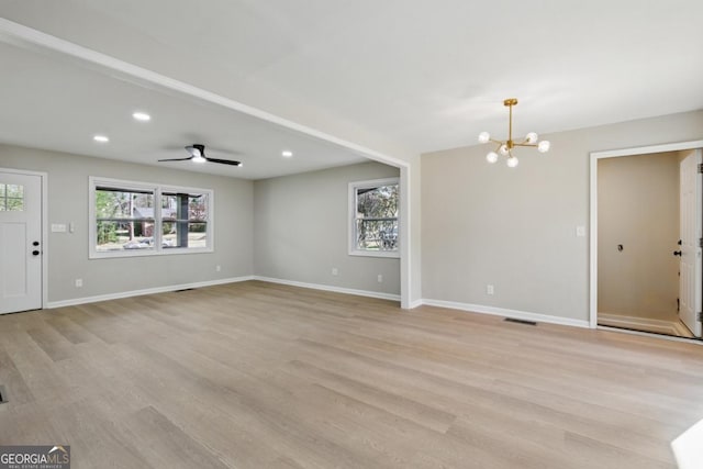 unfurnished living room with recessed lighting, a healthy amount of sunlight, light wood-style floors, and baseboards