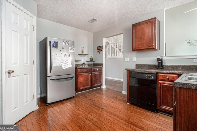 1921 Boulder Gate Dr, Ellenwood, GA 30294 - kitchen with dark countertops, visible vents, dark wood finished floors, dishwasher, and freestanding refrigerator