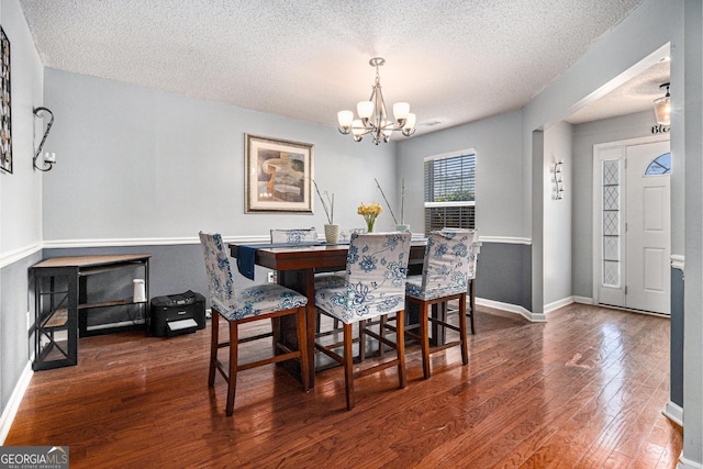 1921 Boulder Gate Dr, Ellenwood, GA 30294 - dining area featuring baseboards, wood-type flooring, a textured ceiling, and an inviting chandelier