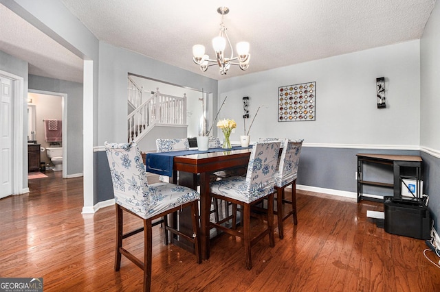 1921 Boulder Gate Dr, Ellenwood, GA 30294 - dining space featuring baseboards, stairs, hardwood / wood-style flooring, a notable chandelier, and a textured ceiling