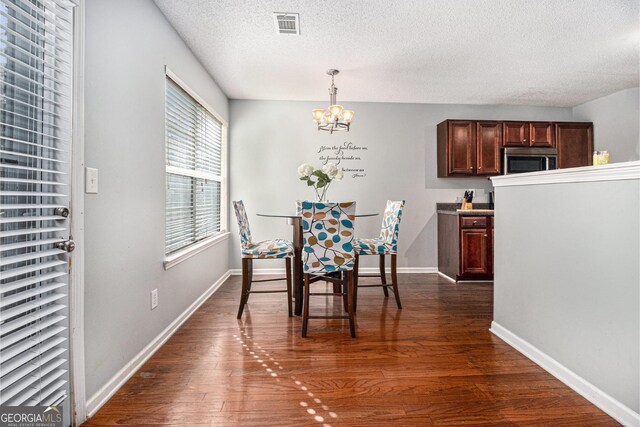 1921 Boulder Gate Dr, Ellenwood, GA 30294 - dining room with visible vents, dark wood-type flooring, baseboards, an inviting chandelier, and a textured ceiling