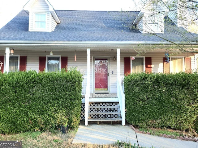 view of front facade with a porch and roof with shingles