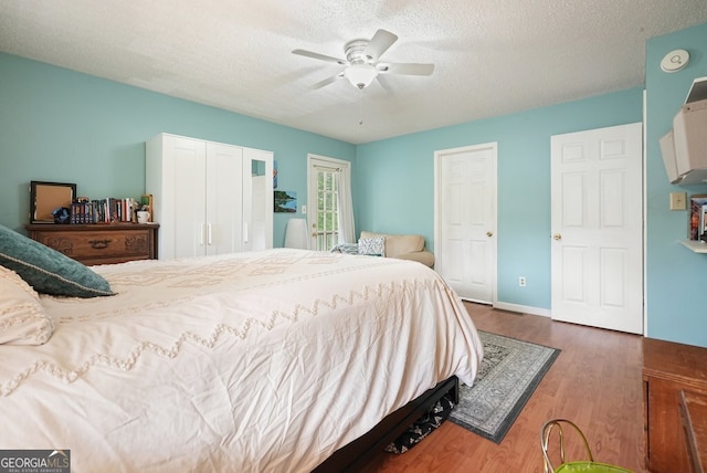 345 Lambeth Dr, Hiram, GA 30141 - bedroom featuring wood finished floors, a textured ceiling, a ceiling fan, and baseboards