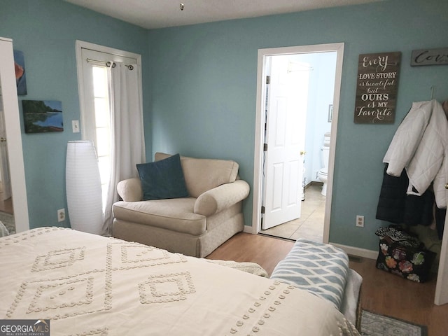345 Lambeth Dr, Hiram, GA 30141 - bedroom featuring wood finished floors, baseboards, and connected bathroom