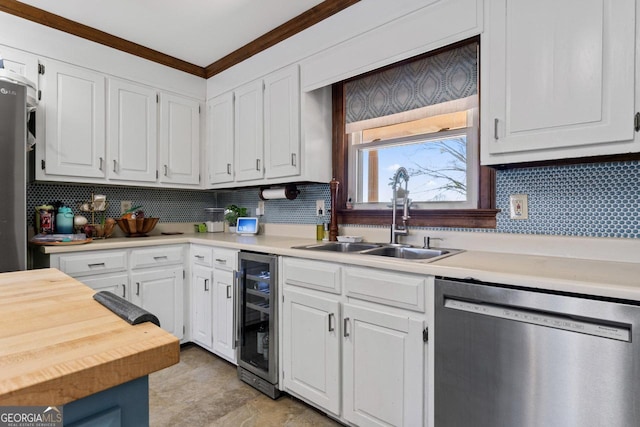 kitchen featuring beverage cooler, ornamental molding, a sink, stainless steel dishwasher, and white cabinets