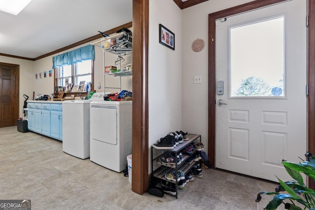 washroom featuring cabinet space, separate washer and dryer, and ornamental molding