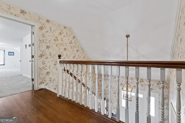 hall featuring wallpapered walls, vaulted ceiling, wood finished floors, and baseboards