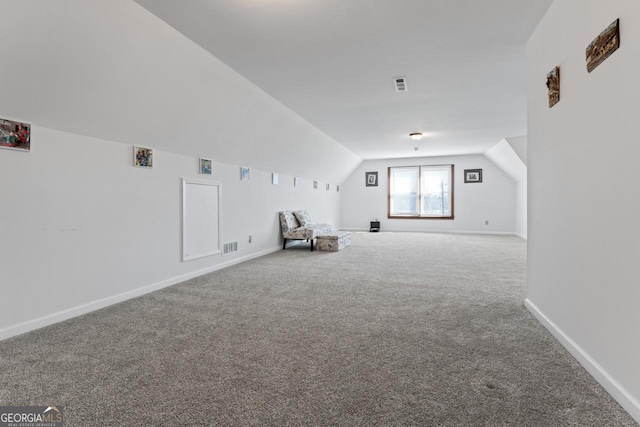 unfurnished room with vaulted ceiling, baseboards, visible vents, and carpet floors