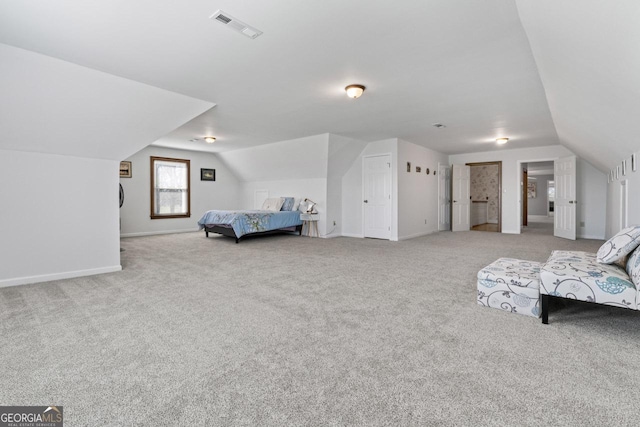 carpeted bedroom featuring visible vents, baseboards, and vaulted ceiling