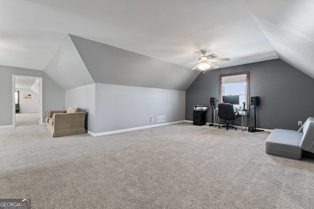 carpeted home office with visible vents, baseboards, lofted ceiling, and a ceiling fan