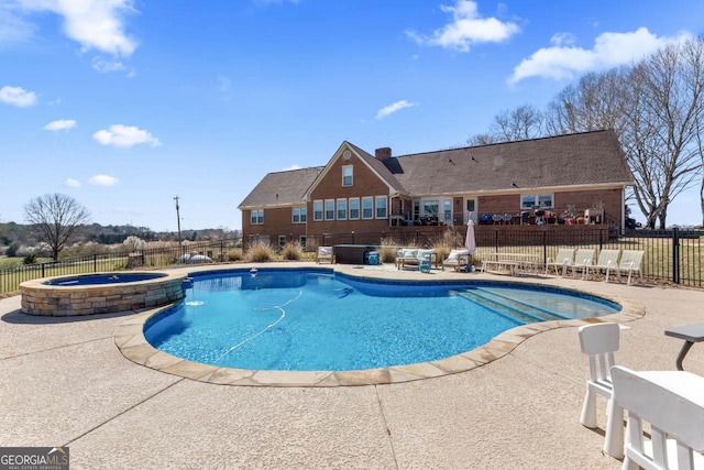 view of pool with a patio, fence, and a pool with connected hot tub