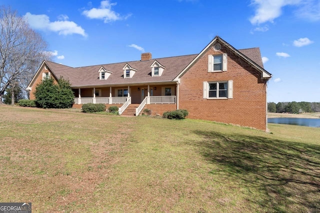 cape cod house featuring brick siding, a porch, and a front yard