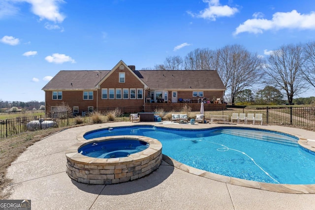 view of swimming pool featuring a patio, a fenced backyard, and a pool with connected hot tub