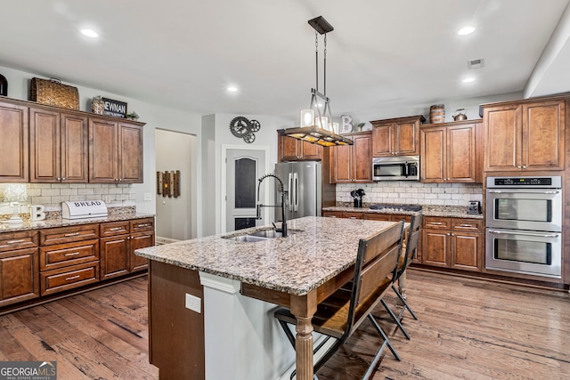 kitchen with a sink, visible vents, appliances with stainless steel finishes, and dark wood-style flooring