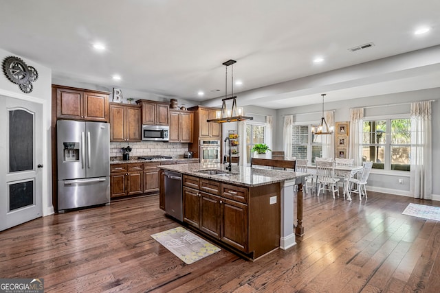 kitchen featuring a sink, dark wood finished floors, light stone countertops, and stainless steel appliances