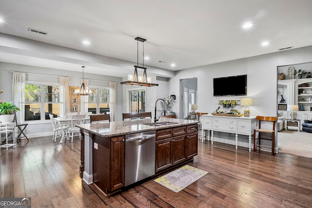 kitchen featuring visible vents, a sink, stainless steel dishwasher, open floor plan, and a chandelier