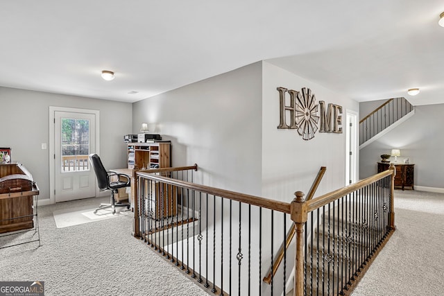 hall featuring an upstairs landing, carpet flooring, and baseboards