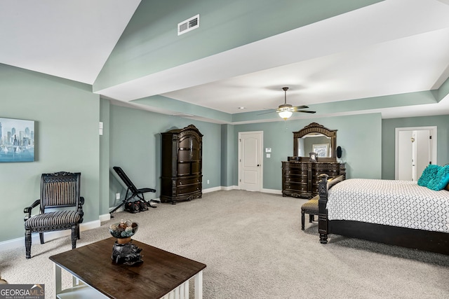 carpeted bedroom featuring a tray ceiling, visible vents, baseboards, and lofted ceiling