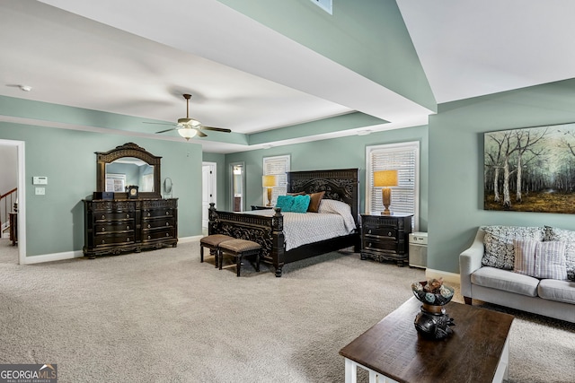 bedroom featuring carpet flooring, ceiling fan, baseboards, and a tray ceiling