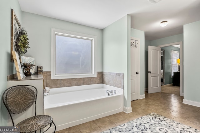 full bathroom with baseboards and a garden tub