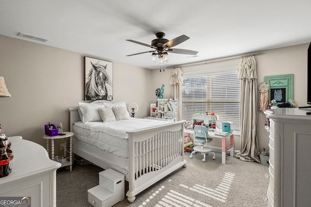 bedroom with visible vents, light colored carpet, and a ceiling fan