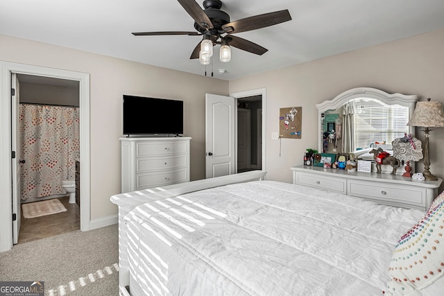 carpeted bedroom with ensuite bath, a ceiling fan, and baseboards