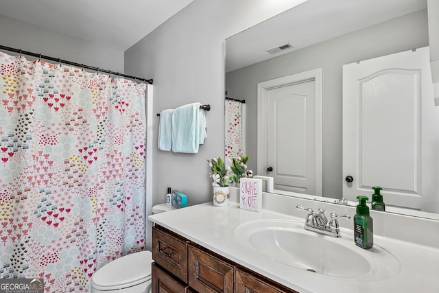 bathroom with vanity, toilet, and visible vents