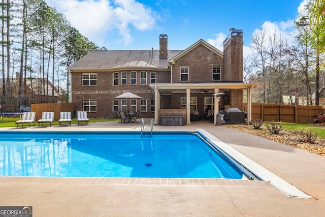 view of pool with a ceiling fan, a trampoline, fence, a fenced in pool, and a patio area