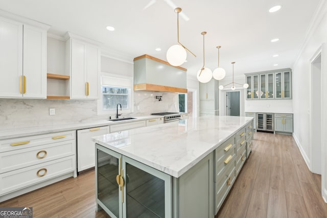 kitchen featuring a sink, white cabinets, crown molding, custom exhaust hood, and dishwasher