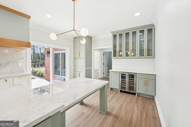 kitchen featuring wine cooler, light wood-style floors, crown molding, baseboards, and light stone countertops