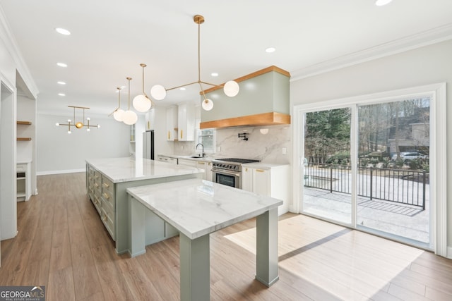 kitchen featuring decorative backsplash, white cabinets, a center island, and crown molding