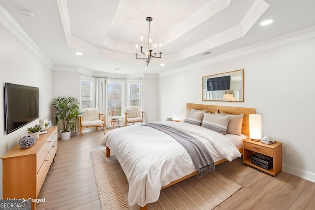 bedroom featuring visible vents, light wood-style flooring, ornamental molding, a raised ceiling, and a chandelier