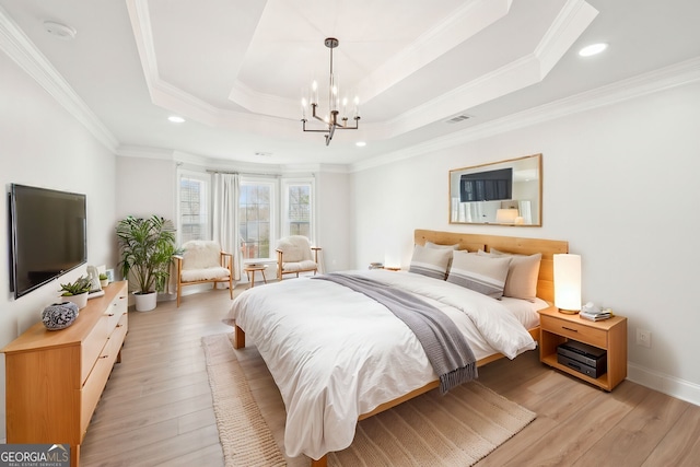 bedroom with visible vents, crown molding, a chandelier, a tray ceiling, and light wood-style floors