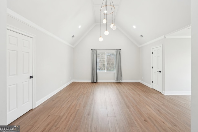 interior space featuring light wood finished floors, crown molding, lofted ceiling, and baseboards