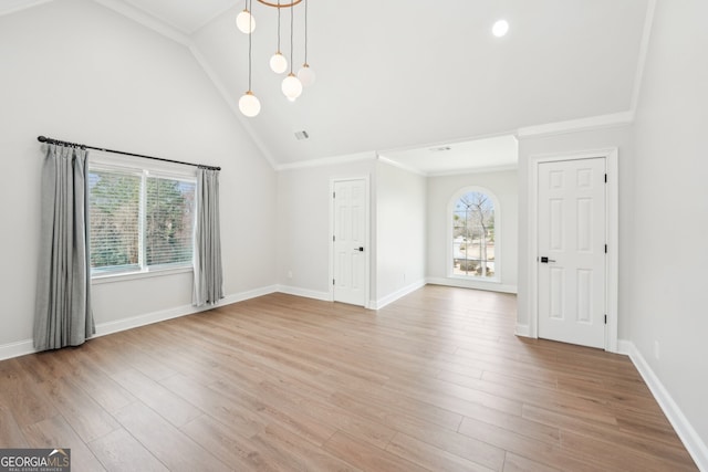 spare room with visible vents, baseboards, crown molding, and light wood finished floors