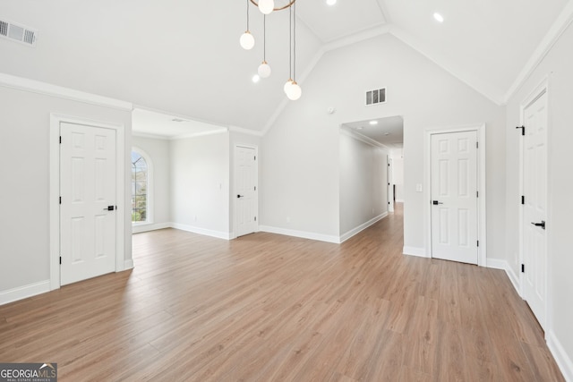 unfurnished living room with visible vents, baseboards, light wood-style floors, and crown molding