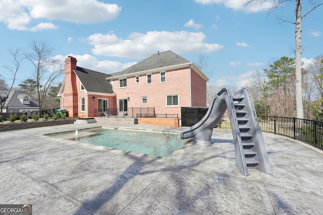 view of swimming pool featuring stairway, fence, a fenced in pool, a water slide, and a patio area