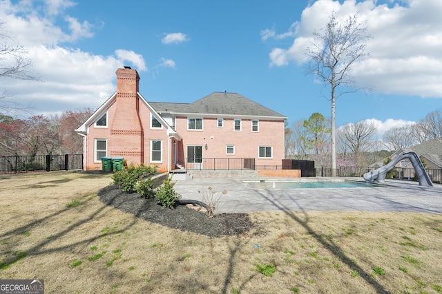 back of property featuring a patio area, fence, a lawn, and brick siding