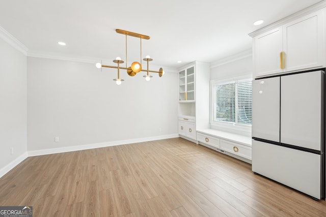 unfurnished dining area with baseboards, light wood-type flooring, a chandelier, and ornamental molding