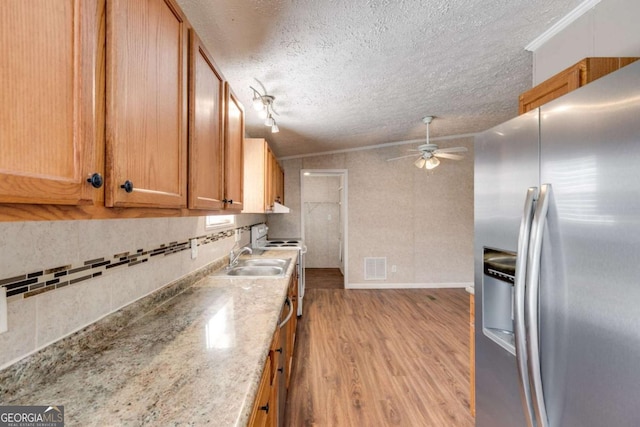 kitchen with visible vents, a ceiling fan, tasteful backsplash, wood finished floors, and stainless steel fridge with ice dispenser