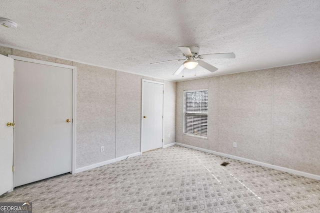 unfurnished bedroom with a ceiling fan, visible vents, a closet, and a textured ceiling