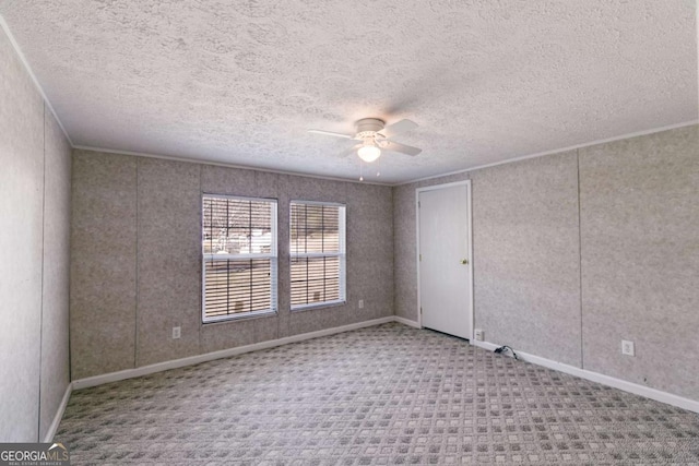 spare room with baseboards, carpet floors, ornamental molding, ceiling fan, and a textured ceiling